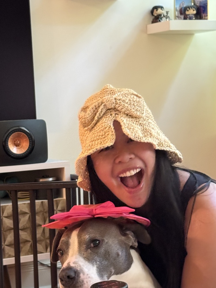 Nhi in a sun hat with their dog
